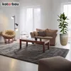 A living room scene with a sofa, armchair, coffee table, rug, floor lamp, and a potted plant. Produktbild-Vorschau