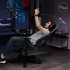 A man is playing a video game while sitting in a gaming chair that is reclined. Produktbild-Vorschau