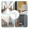 Collage of four scenes showing a white folding shower seat mounted on a wall in different settings, including a hallway, entryway, bathroom, and closet. Produktbild-Vorschau