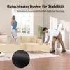 A woman wearing headphones stands on a beige sectional sofa, while a man kneels and adjusts a part of the sofa. A close-up of a black textured material is shown in the foreground. Produktbild-Vorschau