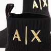 Close-up of a black sock-like shoe with gold 'AX' logo. Produktbild-Vorschau