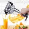 A hand is shown using a manual juicer to squeeze juice into a glass, with various fruits in the foreground. Náhľad obrázku produktu