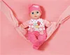 A baby doll is lying in a pink hammock on a pink textured blanket. Náhľad obrázku produktu