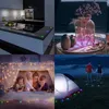 A collage of four images showing RGB LED lights used in different settings: a kitchen counter, a decorative table setting, a child's fort, and a campsite. Produktbild-Vorschau