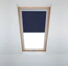 A dark blue roller blind is partially lowered in a wooden-framed skylight window. Produktbild-Vorschau