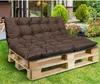 A brown tufted cushion sits on a wooden pallet base in a garden setting. Anteprima dell’immagine prodotto