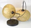 Two pendant lamps made of woven bamboo with black metal accents and a black ceiling plate. Náhled obrázku produktu