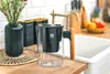 A water filter pitcher is placed on a kitchen counter next to a sink and a vase of flowers. Podgląd zdjęcia produktu