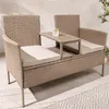 A modern outdoor bench with a built-in table and a drink on it, placed on a wooden deck with a patterned rug. Produktbild-Vorschau