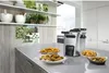A deep fryer is shown on a kitchen counter with bowls of fried food around it. Anteprima dell’immagine prodotto