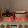 A toy kitchen stove with two pots on it, illuminated by red lights. Podgląd zdjęcia produktu