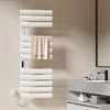 A white electric towel warmer with a towel draped over it, mounted on a light-colored wall in a modern bathroom setting. Produktbild-Vorschau