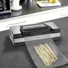 A vacuum sealer machine on a kitchen counter with a bag of asparagus. Anteprima dell’immagine prodotto