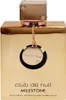 A close-up front view of a gold-colored perfume bottle with a decorative charm hanging from the cap. Voir les images du produit