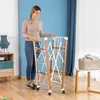 A woman is standing next to a foldable drying rack in a room. Náhled obrázku produktu