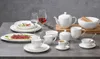 A collection of white ceramic tableware, including plates, bowls, cups, and a teapot, arranged on a gray surface. Anteprima dell’immagine prodotto