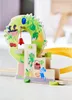 A close-up of a wooden toy train track accessory with colorful illustrations of fruits and animals. Anteprima dell’immagine prodotto