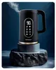 A black electric kettle with a gold trim and a digital display is shown on a decorative stand against a dark blue background. Steam is rising from the spout. Náhled obrázku produktu