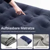 A close-up of a dark blue inflatable mattress with a hand pressing on it, and three smaller images below showing a sleeping bag, an inflatable pillow, and fabric. Produktbild-Vorschau