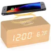 A digital alarm clock with a wooden finish and a smartphone wirelessly charging on top. Produktbild-Vorschau