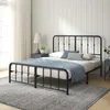 A black metal bed frame with a mattress and bedding in a bedroom setting. Produktbild-Vorschau