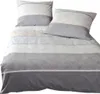 A neatly folded duvet cover and pillowcase set with a striped pattern in shades of gray, white, and sand. Produktbild-Vorschau