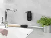 A kitchen sink area with a faucet, soap dispenser, dish brush, and a potted plant. Produktbild-Vorschau