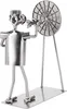 A metal figurine of a dart player throwing a dart at a dartboard, made from nuts, bolts, and other metal hardware. Náhled obrázku produktu