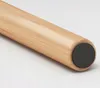 A close-up of the end of a wooden furniture leg with a black protective cap. Náhľad obrázku produktu