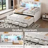 A multi-panel image showcasing a white daybed with storage drawers and a pull-out trundle bed, featuring LED lighting and shelves. The image also includes close-ups of the storage drawers and the headboard area. Produktbild-Vorschau