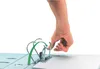 A hand is shown pressing down on the metal rings of a binder to open them, with a green arrow indicating the motion. Voir les images du produit