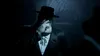 A person in a hat and suit smoking a cigarette. Produktbild-Vorschau