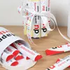 A close-up view of Kinder chocolate bars arranged in a cylindrical shape and decorated with a ribbon, with more bars scattered around. Produktbild-Vorschau
