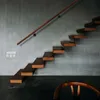 A modern interior with a floating staircase and a wooden chair. Anteprima dell’immagine prodotto