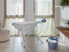 An ironing board with an iron and laundry basket in a room with natural light. Produktbild-Vorschau