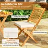 A wooden chair and table set with cushions, set outdoors on a patio. Náhled obrázku produktu
