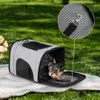 A small dog is sitting in a pet carrier on a picnic blanket outdoors. Anteprima dell’immagine prodotto
