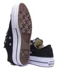 A pair of black Converse sneakers shown from a low angle, with one shoe's sole prominently displayed. Voir les images du produit