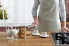 A person is pouring Turkish coffee into small cups on a kitchen counter. Anteprima dell’immagine prodotto