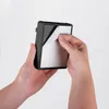 Hands peeling the protective film off the back of a black object. Náhľad obrázku produktu