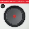 A top-down view of the bottom of a frying pan with a red logo in the center and text at the top. Produktbild-Vorschau