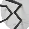 Close-up view of the underside of a round table with a marble pattern and black metal legs. Náhled obrázku produktu
