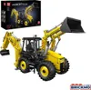 A yellow and black remote-controlled backhoe loader toy, shown from a three-quarter front angle, with its packaging box in the upper left corner. Voir les images du produit