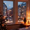 A cozy indoor scene with a Christmas tree and decorated window overlooking a snowy street at dusk. Produktbild-Vorschau
