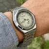 A close-up shot of a man's wrist wearing a Citizen watch, with a blurred background of greenery. Podgląd zdjęcia produktu