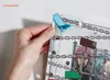 A hand is holding a board game piece, showing a close-up of a game board with chains and illustrated characters behind bars. Podgląd zdjęcia produktu