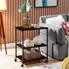 A kitchen cart with shelves and wheels, placed next to a sofa in a living room setting. Produktbild-Vorschau