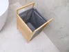 A laundry basket made of bamboo and fabric is placed on a tiled floor next to a bathtub. Náhľad obrázku produktu
