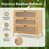 A bamboo dresser with three drawers, featuring ribbed glass fronts, set against a blurred green bamboo forest background. Informational icons and text are overlaid on the left side. Podgląd zdjęcia produktu