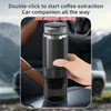 A hand holding a portable coffee maker inside a car. Náhled obrázku produktu